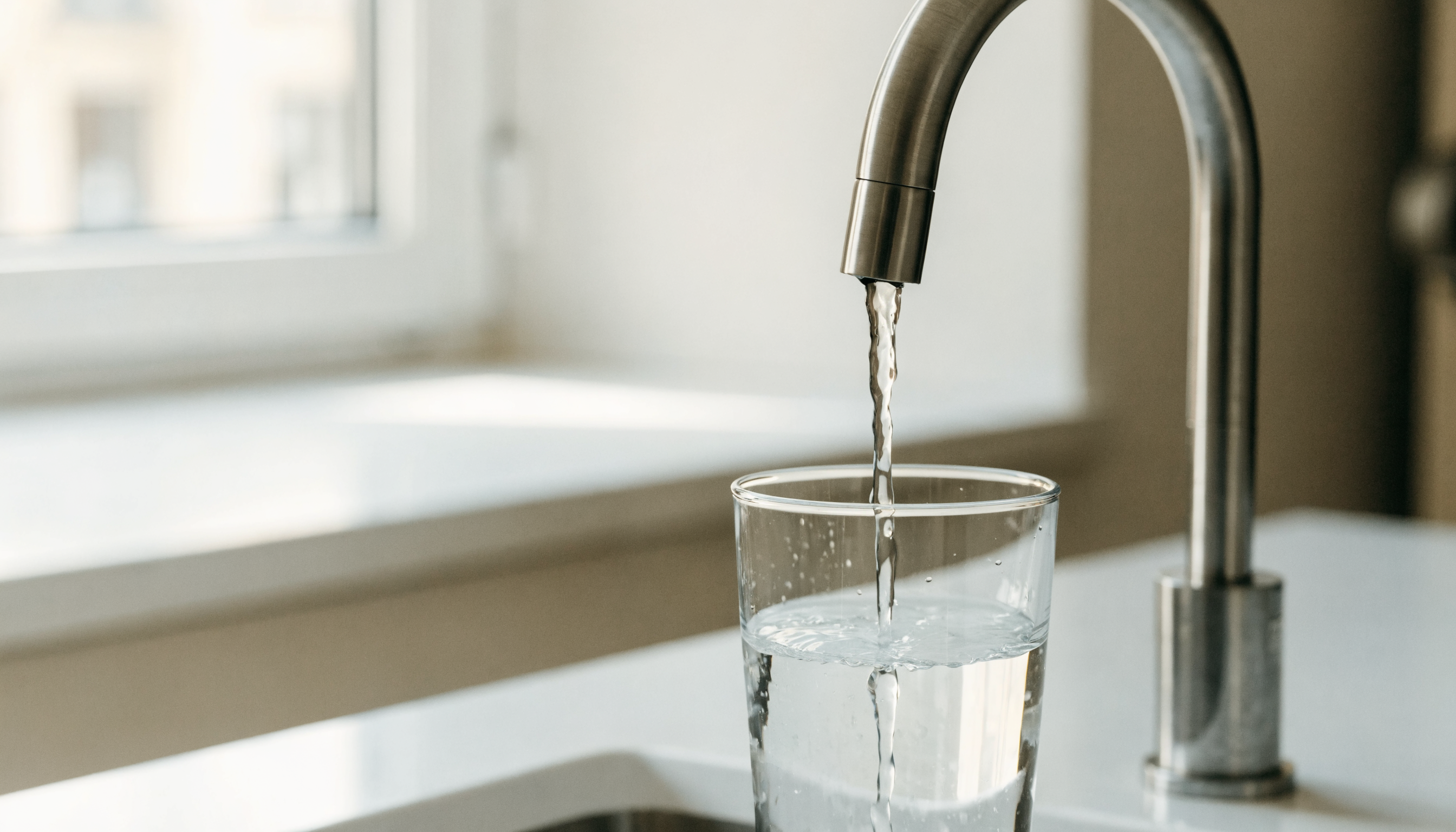 Glas med rent vand fyldt fra vandhane efter omvendt osmose-filtrering